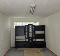 NA PREDAJ - GARÁŽ - Topoľčany - Interiér garáže s nábytkom a osvetlením, podlaha s dreveným dekorom.