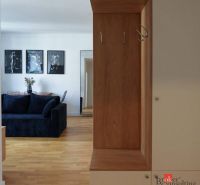 Moderný 2i apartmán v novostavbe v Starom Meste - Interiér 2-izbového bytu s podlahou s dreveným dekorom a tmavým gaučom.