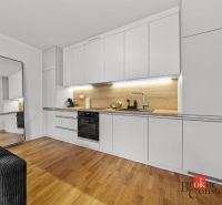 Moderný 2i apartmán v novostavbe v Starom Meste - Svetlá kuchyňa v 2-izbovom byte s bielymi skrinkami a podlahou s dreveným dekorom.