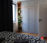 Moderný 2i apartmán v novostavbe v Starom Meste - Spálňa s podlahou s dreveným dekorom, vstavanou skriňou a izbovou rastlinou v 2-izbovom byte.