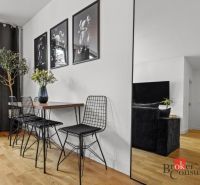 Moderný 2i apartmán v novostavbe v Starom Meste - Jedálenský kút s dreveným stolom, kovovými stoličkami a podlahou s dreveným dekorom.
