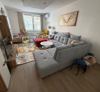 3 izbový byt s balkónom Topoľčany  - Obývačka v 3-izbovom byte s pohodlnou sedačkou a podlahou s dreveným dekorom.