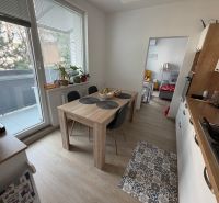 3 izbový byt s balkónom Topoľčany  - Kuchyňa v 3-izbovom byte s podlahou s dreveným dekorom a balkónom.
