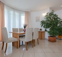 Rezidenčná vila v širšom centre Piešťan - Jedáleň v rodinnom dome s elegantným stolom, stoličkami, izbovým rastlinom a umením na stene.