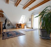 Rezidenčná vila v širšom centre Piešťan - Podkrovná miestnosť rodinného domu s podlahou s dreveným dekorom a drevenými trámami.