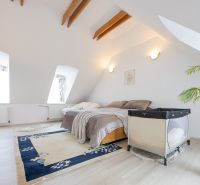 Rezidenčná vila v širšom centre Piešťan - Spálňa v rodinnom dome s posteľou, drevenými trámami a podlahou s dreveným dekorom.