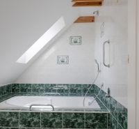 Rezidenčná vila v širšom centre Piešťan - Kúpeľňa v rodinnom dome s vaňou obloženou zelenými kachličkami a strešným oknom.