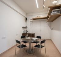 Prenájom 148,25 m² showroom, predajňa | Zlatovce - Svetlá obchodné priestory s kruhovým stolom a minimalistickým nábytkom.