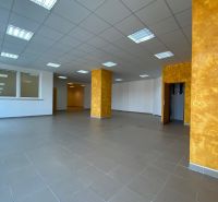 Prenájom 148,25 m² showroom, predajňa | Zlatovce - Interiér obchodných priestorov s dlažbou a oranžovými stĺpmi.