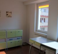 PRENÁJOM: SLNEČNÝ 3 IZBOVÝ BYT S BALKÓNOM A PARKOVANÍM, CENTRUM - Detská izba v 3-izbovom byte s podlahou s dreveným dekorom, zelené skrinky a písací stôl.