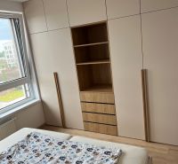 Kompletne zariadený 3-izbový byt s balkónom | PRÚDY Trnava - Spálňa v 3-izbovom byte s veľkou vstavanou skriňou a podlahou s dreveným dekorom.