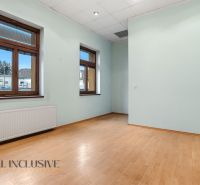  POLYFUNKČNÝ OBJEKT | CHRABRANY | TOPOĽČANY - Izba v budove s podlahou s dreveným dekorom, veľkými oknami a bielym radiátorom.