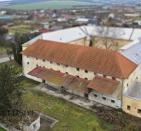 AREÁL | SKLAD | VÝROBNÁ HALA | KOVARCE | TOPOĽČANY - Výrobné priestory na Hlavnej ulici v Kovarciach s viditeľnou strechou a okolím.