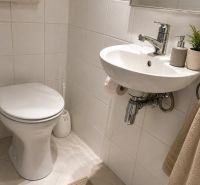 2- izbový byt na  ulici Studenohorská, Bratislava-Lamač - Toaleta v 2-izbovom byte so svetlými obkladačkami a umývadlom.