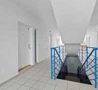  | 3 izbový byt o výmere 73m2 + balkón - Chodba s bielymi dverami a modrým zábradlím v bytovom dome na Robotníckej ulici v Senci.
