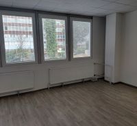 Klimatizovaná kancelária 39 m2 s umývadlom na Tomášikovej ul.  - Kancelárie s veľkými oknami, neutrálne steny, podlaha s dreveným dekorom.