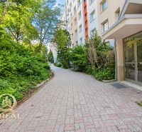  3-izbový byt Karlova Ves – Dlhé diely, 75,79 m², možnosť garáže* - Chodník pri bytovom dome na Hlaváčikovej ulici v Bratislave, Karlova Ves, obklopený zeleňou.