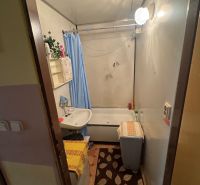 Na predaj Garsônka, 24,5 m2, s perfektnou polohou.  - Kúpeľňa v garsónke s vaňou, umývadlom a modrým závesom.