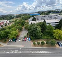 Na predaj Garsônka, 24,5 m2, s perfektnou polohou.  - Pohľad na parkovisko, zeleň a budovu z výšky na Novomeského, Nitra - Klokočina.