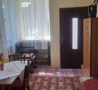 GAZDOVSKÝ DOM so záhradou a humnom, Ostrá Lúka pri Zvolene - Interiér rodinného domu s drevenými dverami, stolom, stoličkami a koberecom.