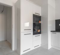 Na predaj nový moderný 4-izbový rodinný dom s terasou a záhradou - Kuchyňa v rodinnom dome s bielymi lesklými skrinkami a vstavanými spotrebičmi.