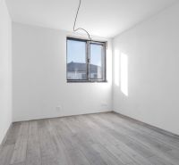 Na predaj nový moderný 4-izbový rodinný dom s terasou a záhradou - Prázdna miestnosť v rodinnom dome s podlahou s dreveným dekorom a oknom.