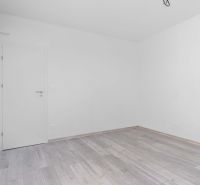 Na predaj nový moderný 4-izbový rodinný dom s terasou a záhradou - Prázdna biela miestnosť v rodinnom dome s podlahou s dreveným dekorom.