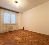 3-izbový byt s veľkou loggiou - Prázdna izba v 3-izbovom byte s podlahou s dreveným dekorom a závesom na okne.