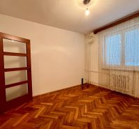 3-izbový byt s veľkou loggiou - Izba v 3-izbovom byte s podlahou s dreveným dekorom a oknom s bielou záclonou.