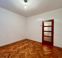 3-izbový byt s veľkou loggiou - Izba so stenami bielej farby a podlahou s dreveným dekorom v 3-izbovom byte.