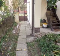 2 budovy v centre Komárna na predaj! - Chodník vedľa rodinného domu v Komárne, vedúci k vstupnej bráne, obklopený zeleňou.
