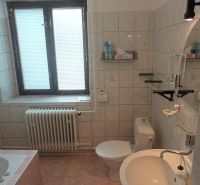 2 budovy v centre Komárna na predaj! - Kúpeľňa v rodinnom dome s vaňou, umývadlom, zrkadlom a oknom s tienidlom.