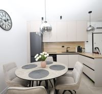 Chorvátsko, Vodice - zariadený apartmán s výhľadom na more - Kuchyňa v rekreačnom apartmáne s okrúhlym stolom a svetlým nábytkom.