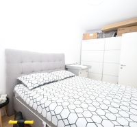Chorvátsko, Vodice - zariadený apartmán s výhľadom na more - Spálňa v rekreačnom apartmáne s posteľou, nočným stolíkom a úložnými priestormi.