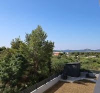 Chorvátsko, Vodice - zariadený apartmán s výhľadom na more - Výhľad z rekreačného apartmánu vo Vodiciach, zahŕňajúci zeleň a pohorie v diaľke.