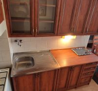 Na predaj 2 izbový byt 62m2 s 3 balkónmi - Nové Zámky  - Kuchyňa v 2-izbovom byte s drevenými kuchynskými skrinkami a jedálenským stolom.