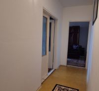 Na predaj 2 izbový byt 62m2 s 3 balkónmi - Nové Zámky  - Chodba 2-izbového bytu so svetlým kobercom a podlahou s dreveným dekorom.