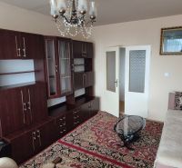 Na predaj 2 izbový byt 62m2 s 3 balkónmi - Nové Zámky  - Obývacia izba v 2-izbovom byte s dreveným nábytkom a kryštálovým lustrom.