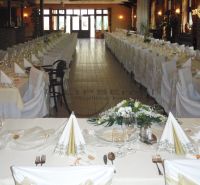 NA PREDAJ jedinečný gastro eventový areál v lesoparku Berek Nové Zámky - Slávnostne prestreté stoly a dekorácie v gastro priestoroch s podlahou s dreveným dekorom.