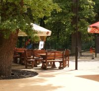 NA PREDAJ jedinečný gastro eventový areál v lesoparku Berek Nové Zámky - Terasa s drevenými lavicami a stolmi v gastro priestoroch na Bereku v Nových Zámkoch.
