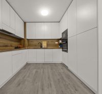 NA PREDAJ: 3-izbový apartmán, MATADORKA, Bratislava - Petržalka - Kuchyňa v 3-izbovom byte s bielymi skrinkami a podlahou s dreveným dekorom.