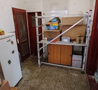 Rodinný dom na predaj Komárno - Perspektíva miestnosti s regálom a kartónmi v rodinnom dome.