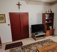 Rodinný dom na predaj Komárno - Obývacia izba v rodinnom dome s nábytkom a krížom na stene.