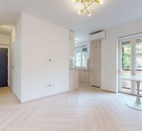 NA PRENÁJOM ZREKONŠTRUOVANÝ 3 IZBOVÝ BYT S GARÁŽOU V CENTRE MESTA - Obývacia izba v 3-izbovom byte s podlahou s dreveným dekorom a balkónovými dverami.