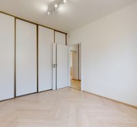 NA PRENÁJOM ZREKONŠTRUOVANÝ 3 IZBOVÝ BYT S GARÁŽOU V CENTRE MESTA - Izba v 3-izbovom byte s veľkou skriňou a podlahou s dreveným dekorom.