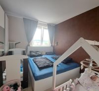 Priestranný 3-izbový byt s dvoma balkónmi na prenájom - Spálňa s detskou postieľkou v 3-izbovom byte, podlaha s dreveným dekorom.