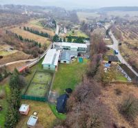 Kopanice Resort | Výnosová investícia - Letecký pohľad na Hotely a penzióny v Podkylave s tenisovým kurtom a zelenými plochami.
