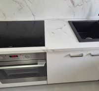 Na prenájom kompletne prerob. NOVÝ 2 izbový byt čiast.zar. Nové Zámky - Kuchynská linka s indukčnou varnou doskou a čiernym drezom v 2-izbovom byte.