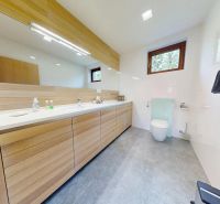 Pripravujeme do ponuky jedinečný apartmánový bytový dom Donovaly  - Moderná kúpeľňa v chate so svetlým drevom a veľkým zrkadlom.