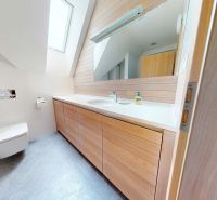 Pripravujeme do ponuky jedinečný apartmánový bytový dom Donovaly  - Kúpeľňa v chate s dreveným dekorom, vybavená umývadlom a veľkým zrkadlom.